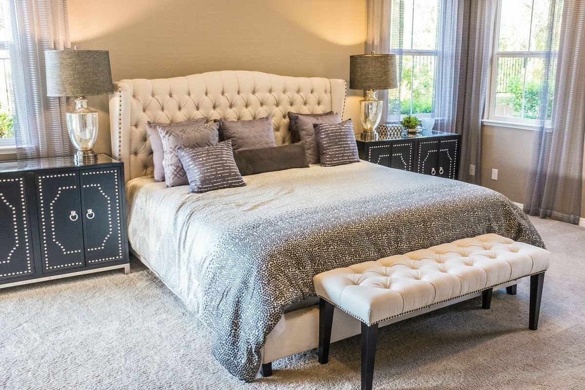 A luxurious upholstered bed dressed in layered bedding